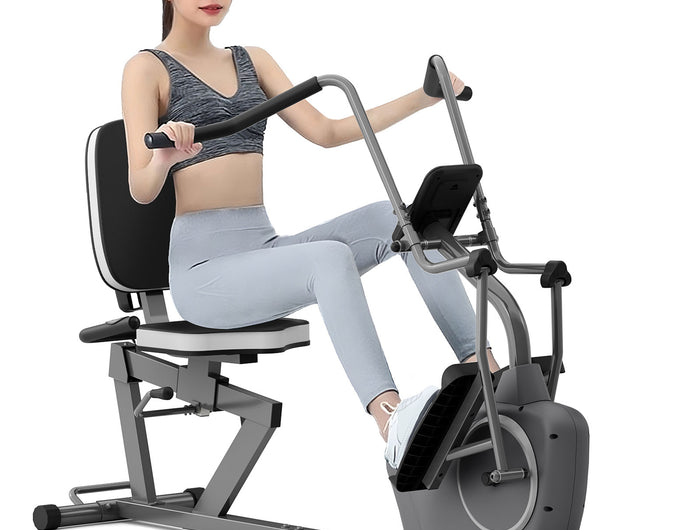 a women is riding on a recumbent bike with arm exerciser