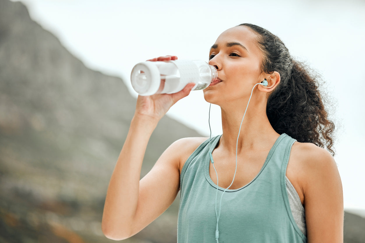 a  women drinks water after workout