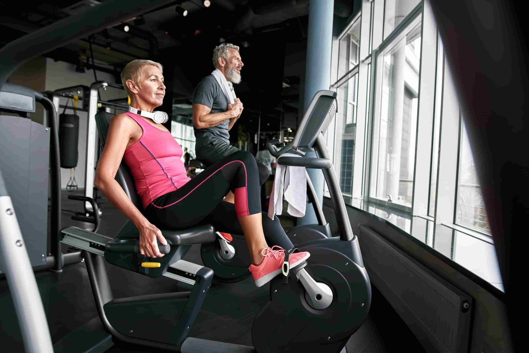 a older women is riding a recumbent bike in a gym